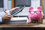Hände mit Aktenordner, Taschenrechner und Sparschwein